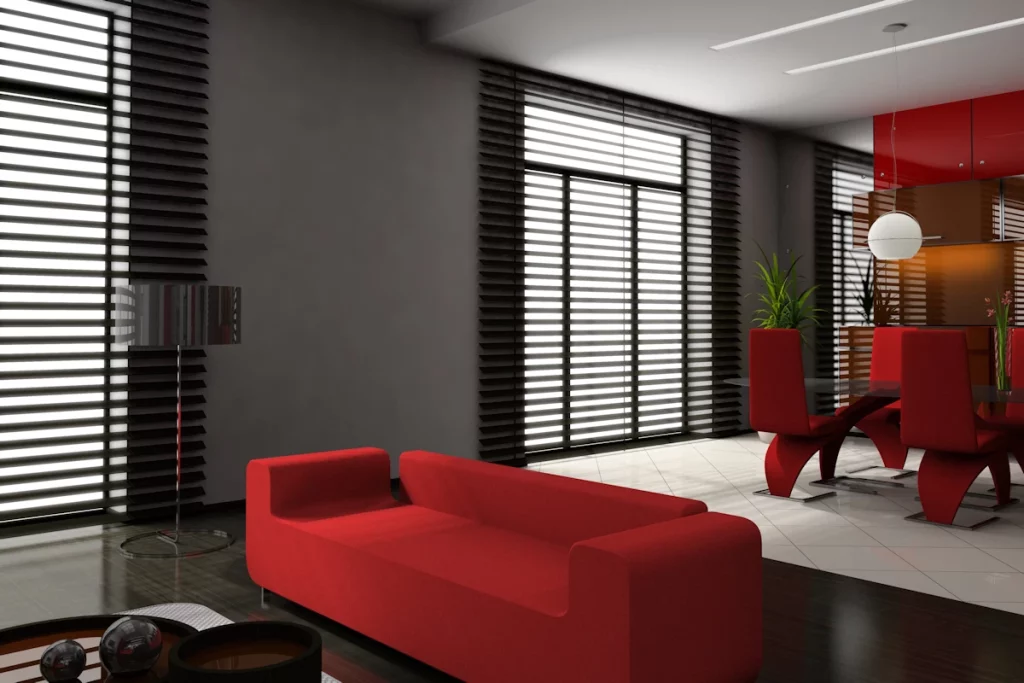 salon z roletami drewnianymi w oknach i czerwonumi sofami